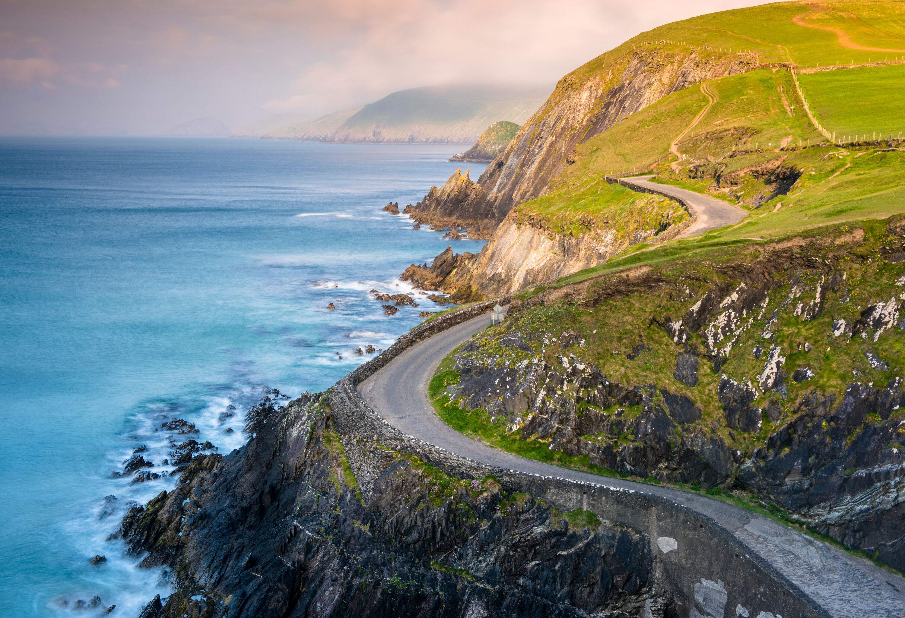 A winding road along a steep and rocky coastline.